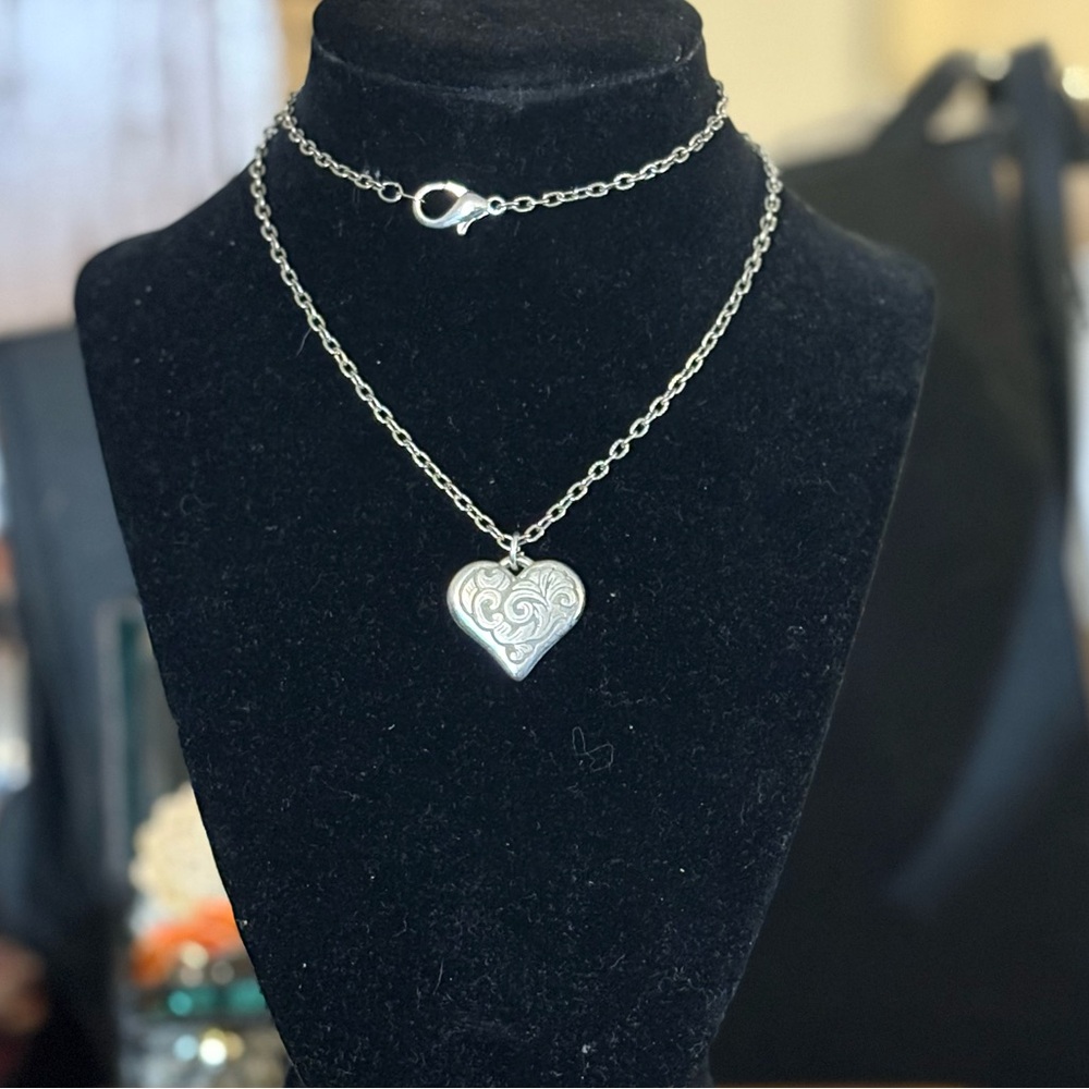 24” long silver tone necklace with an etched heart shaped pendant.